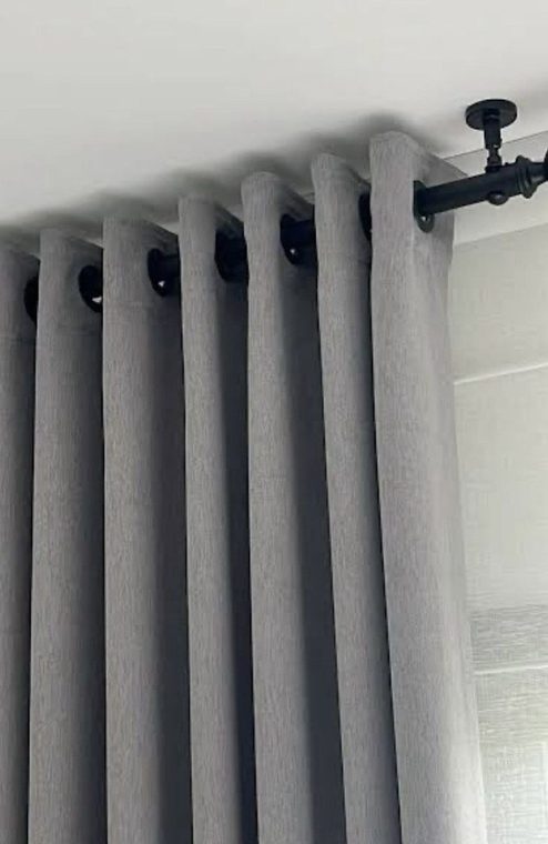Grey curtains on a black ceiling rod
