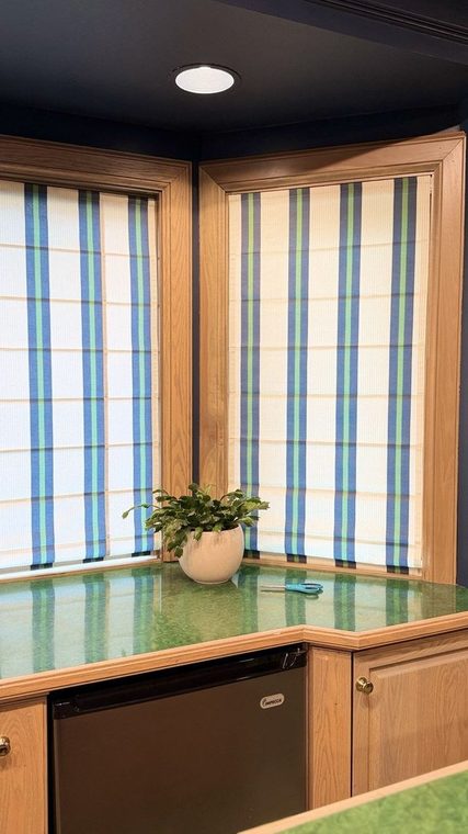 Striped Roman shades along a bay window