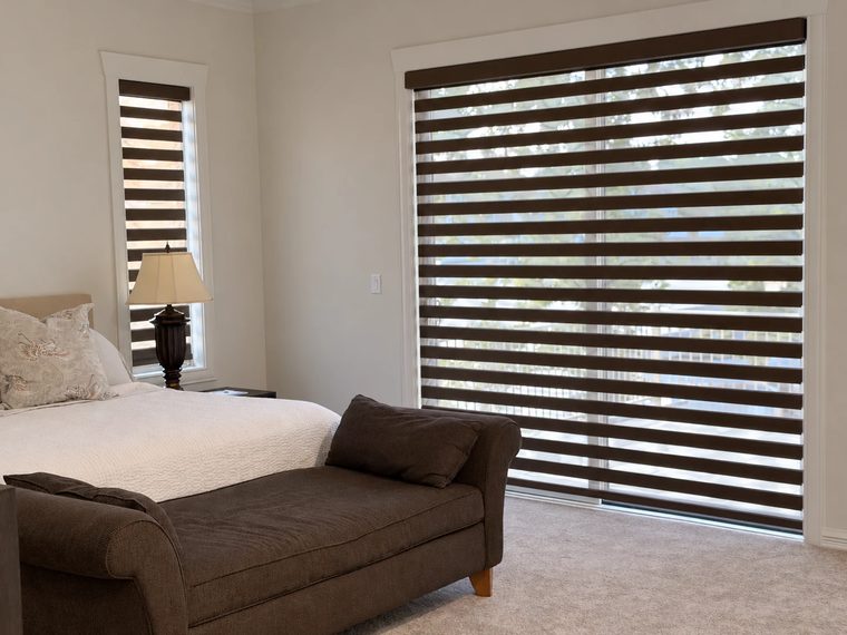 Zebra shades in a bedroom with a chaise longue